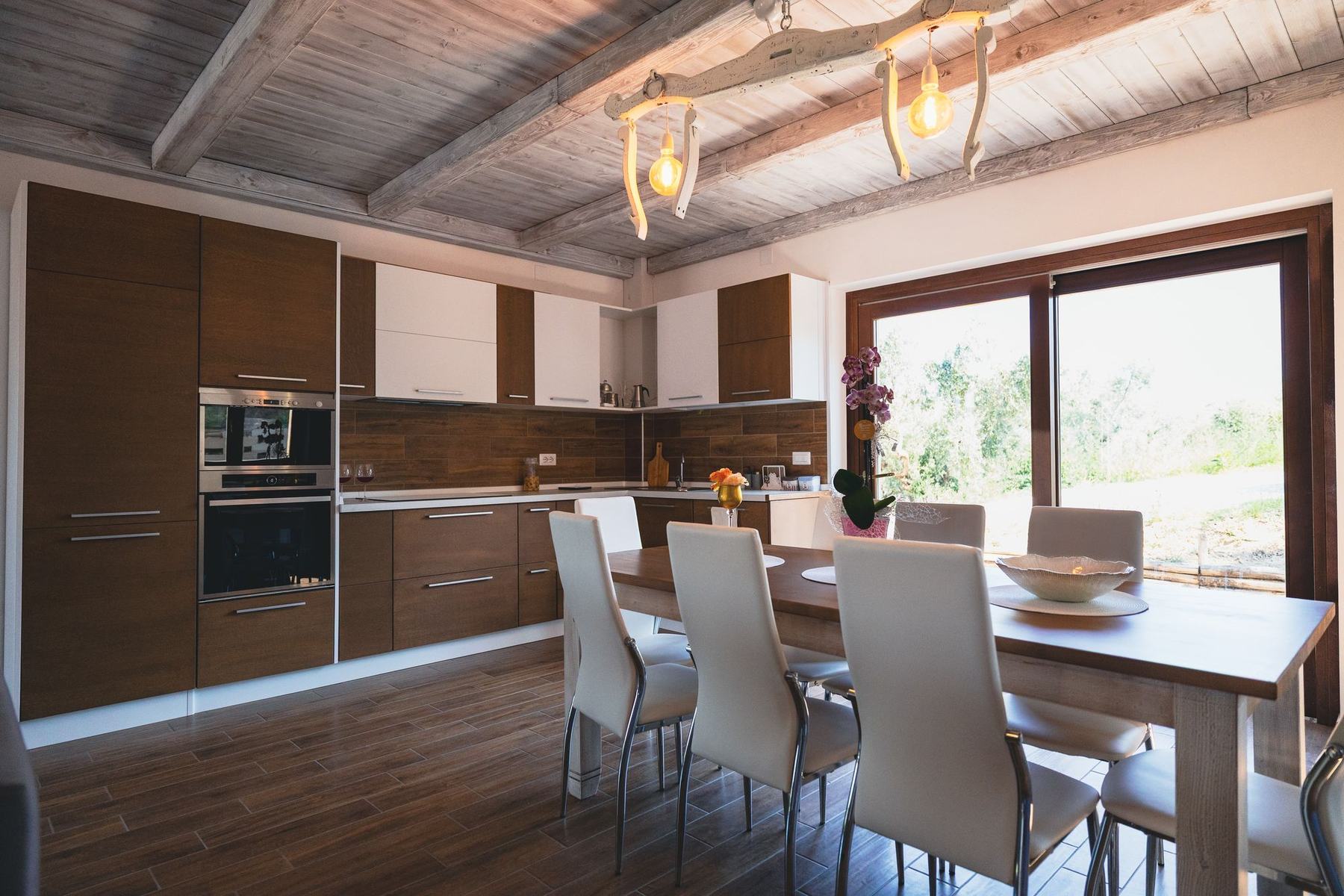 Cucina con tavolo da pranzo e vetrata sul giardino